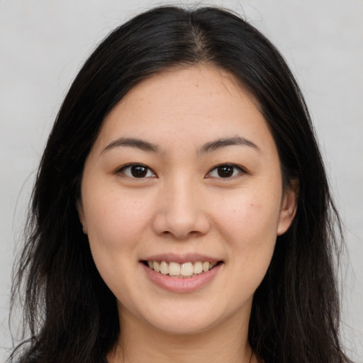 Joyful asian young-adult female with long  brown hair and brown eyes