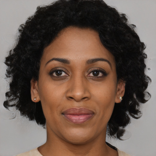 Joyful black young-adult female with medium  brown hair and brown eyes