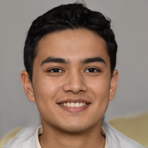 Joyful latino young-adult male with short  brown hair and brown eyes