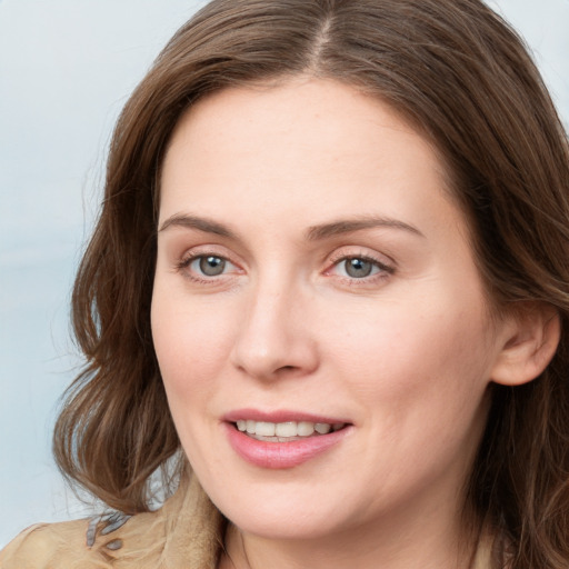 Joyful white young-adult female with long  brown hair and blue eyes