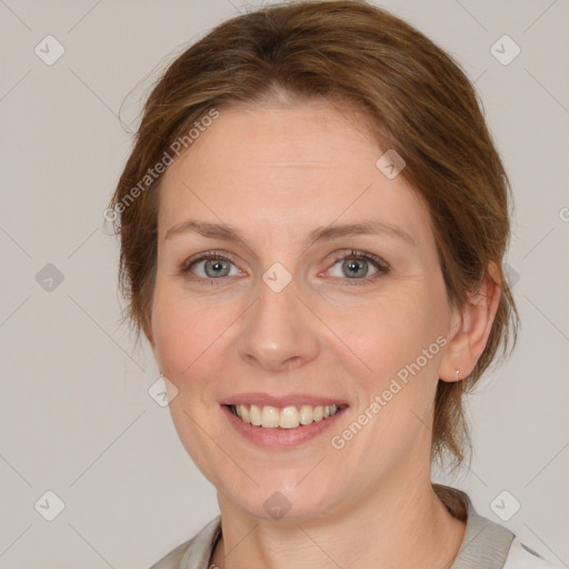 Joyful white adult female with medium  brown hair and grey eyes