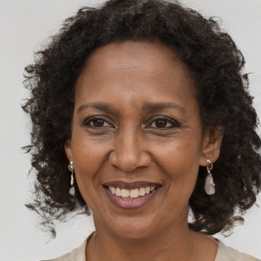 Joyful black adult female with long  brown hair and brown eyes