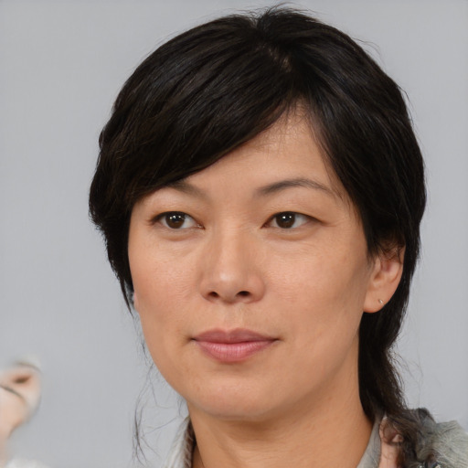 Joyful asian adult female with medium  brown hair and brown eyes