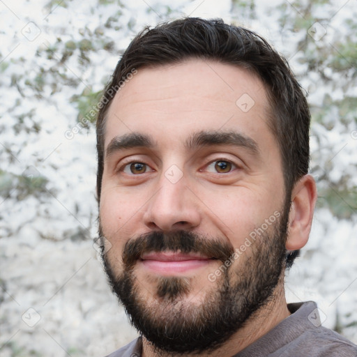 Joyful white young-adult male with short  black hair and brown eyes