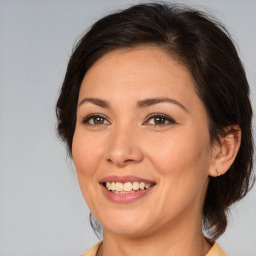 Joyful white adult female with medium  brown hair and brown eyes