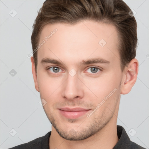 Joyful white young-adult male with short  brown hair and grey eyes