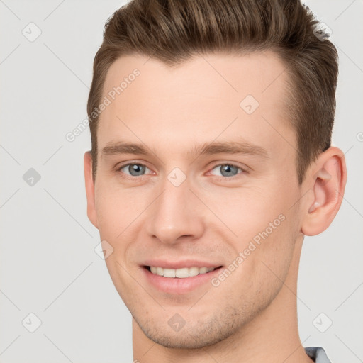 Joyful white young-adult male with short  brown hair and grey eyes