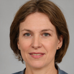 Joyful white adult female with medium  brown hair and grey eyes