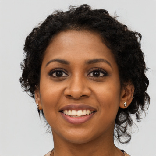 Joyful black young-adult female with long  brown hair and brown eyes