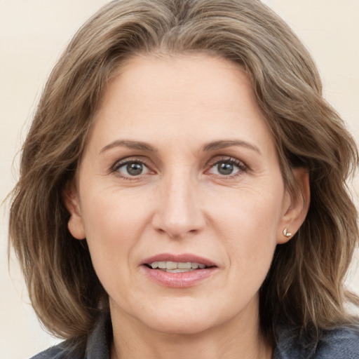 Joyful white adult female with medium  brown hair and grey eyes