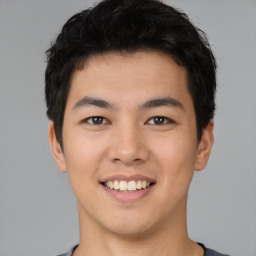 Joyful asian young-adult male with short  black hair and brown eyes