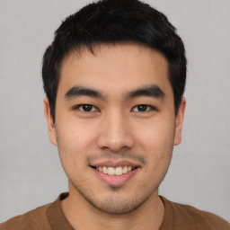 Joyful asian young-adult male with short  black hair and brown eyes