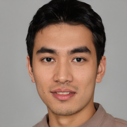 Joyful asian young-adult male with short  black hair and brown eyes