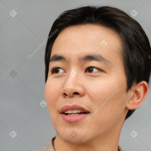 Joyful asian young-adult male with short  brown hair and brown eyes