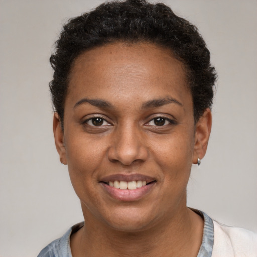 Joyful black young-adult female with short  black hair and brown eyes