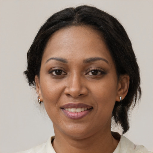 Joyful black adult female with medium  brown hair and brown eyes