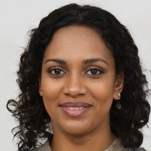 Joyful black young-adult female with long  brown hair and brown eyes