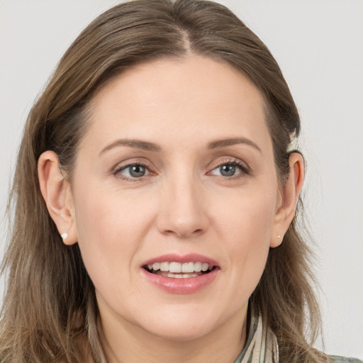 Joyful white young-adult female with long  brown hair and grey eyes