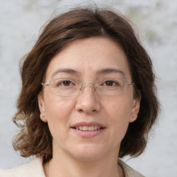 Joyful white adult female with medium  brown hair and grey eyes