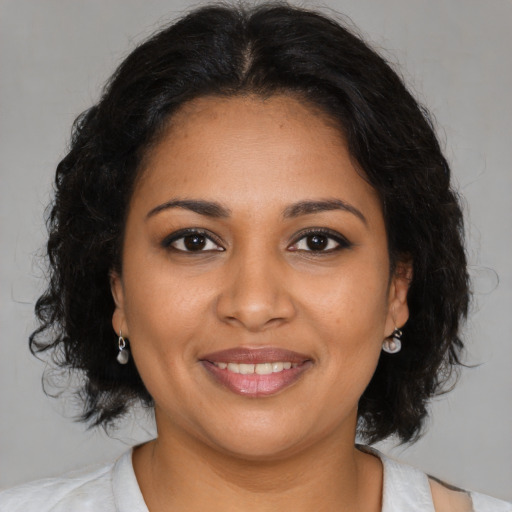 Joyful black young-adult female with medium  brown hair and brown eyes