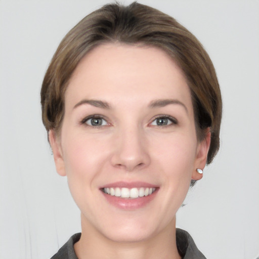 Joyful white young-adult female with short  brown hair and grey eyes