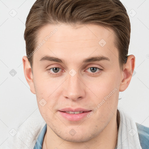 Joyful white young-adult male with short  brown hair and grey eyes