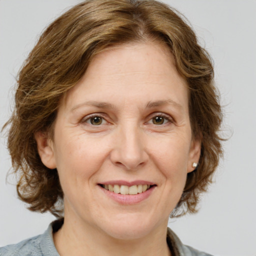 Joyful white adult female with medium  brown hair and blue eyes