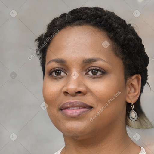 Joyful black young-adult female with long  black hair and brown eyes