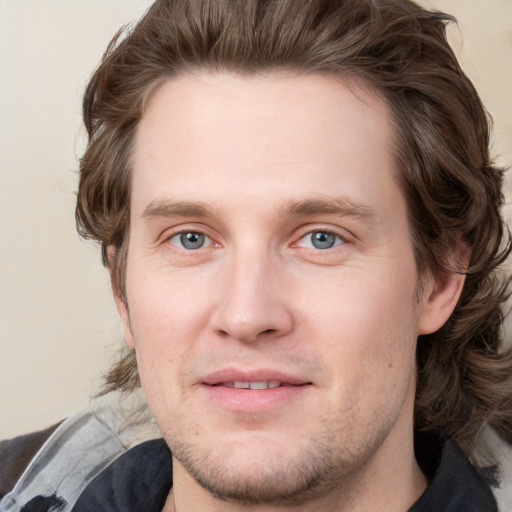 Joyful white young-adult male with medium  brown hair and grey eyes