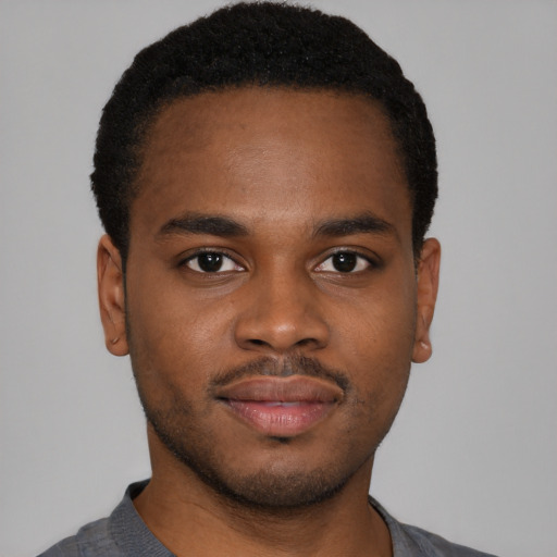 Joyful black young-adult male with short  brown hair and brown eyes