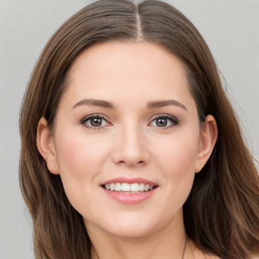 Joyful white young-adult female with long  brown hair and grey eyes