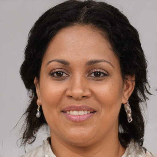 Joyful latino adult female with medium  brown hair and brown eyes