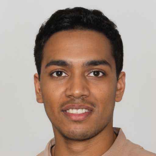 Joyful black young-adult male with short  black hair and brown eyes