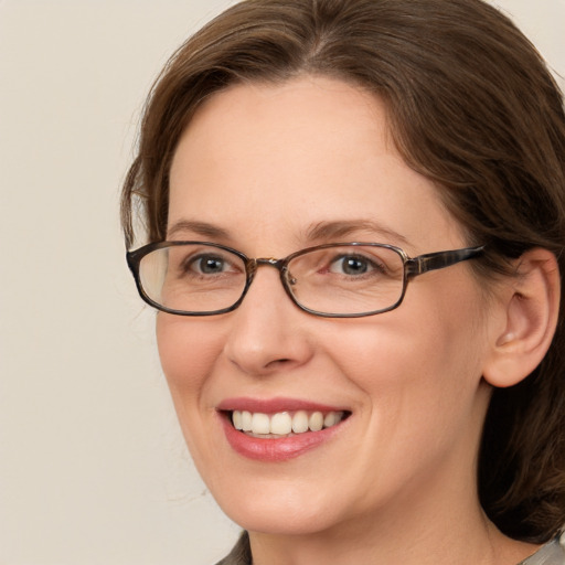 Joyful white adult female with medium  brown hair and grey eyes