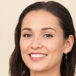 Joyful white young-adult female with long  brown hair and brown eyes