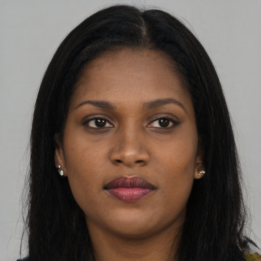 Joyful black young-adult female with long  brown hair and brown eyes