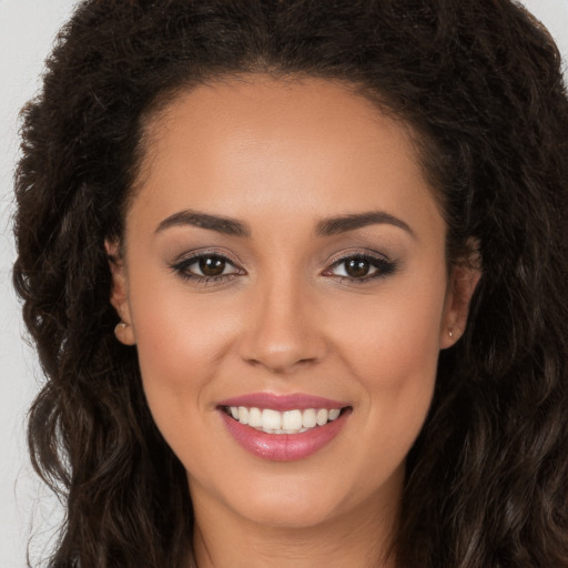 Joyful white young-adult female with long  brown hair and brown eyes