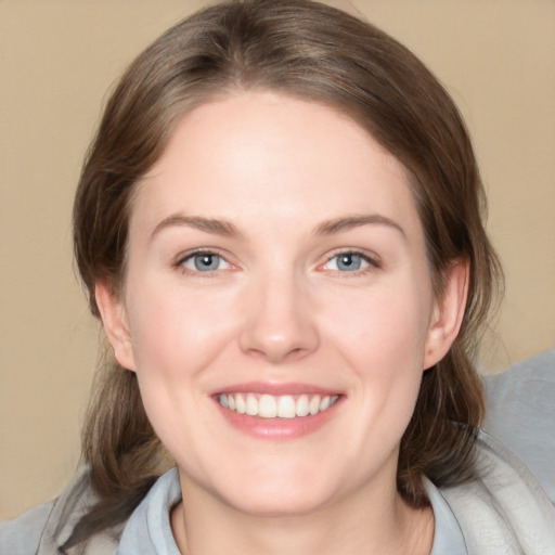 Joyful white young-adult female with medium  brown hair and grey eyes