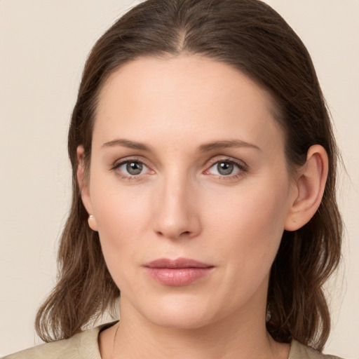 Joyful white young-adult female with medium  brown hair and green eyes