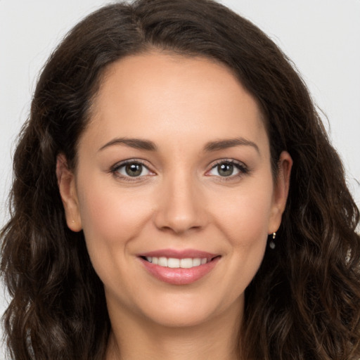 Joyful white young-adult female with long  brown hair and brown eyes