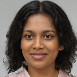 Joyful black young-adult female with medium  brown hair and brown eyes