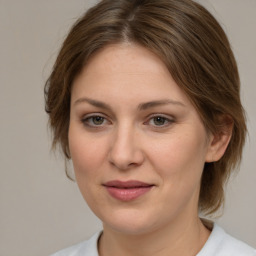 Joyful white young-adult female with medium  brown hair and green eyes