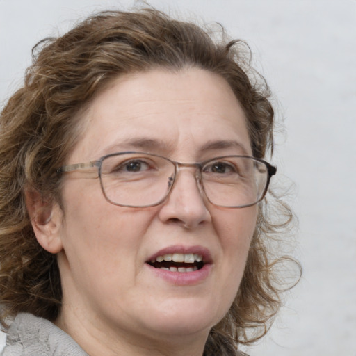 Joyful white adult female with medium  brown hair and blue eyes