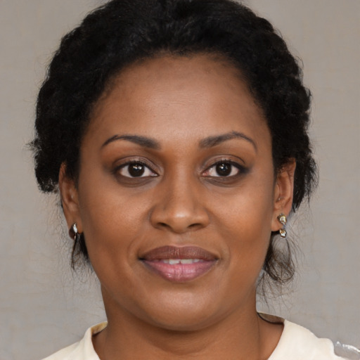 Joyful black adult female with medium  brown hair and brown eyes