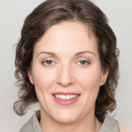 Joyful white young-adult female with medium  brown hair and green eyes