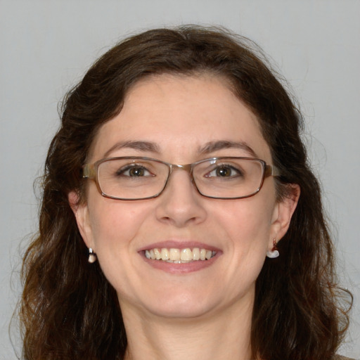 Joyful white adult female with medium  brown hair and green eyes