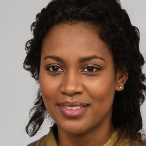 Joyful black young-adult female with long  black hair and brown eyes