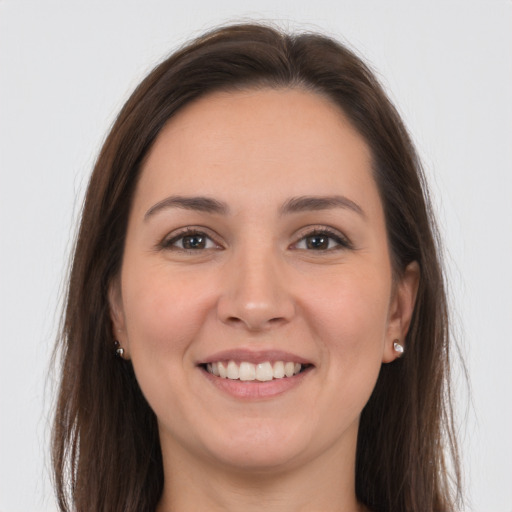 Joyful white young-adult female with long  brown hair and grey eyes