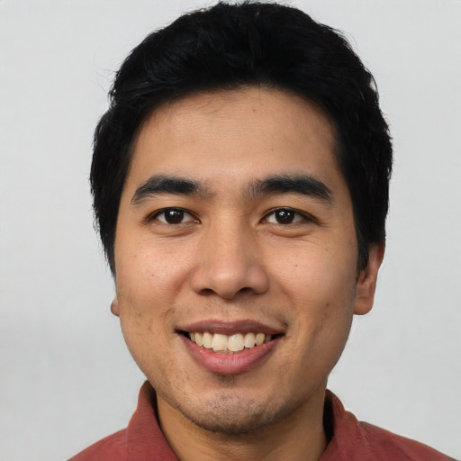 Joyful latino young-adult male with short  black hair and brown eyes