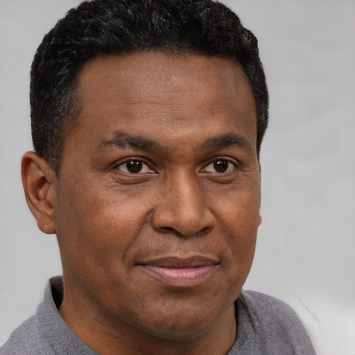 Joyful latino adult male with short  brown hair and brown eyes